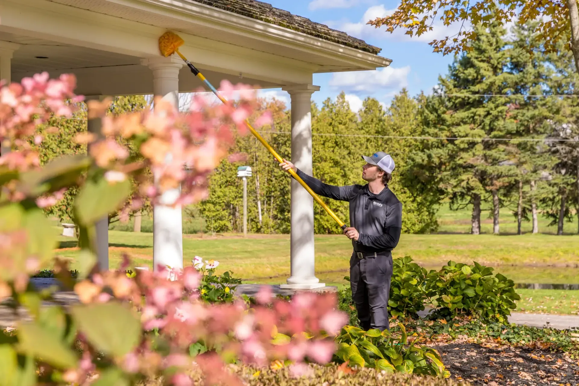 Professional pest control technician spraying house exterior